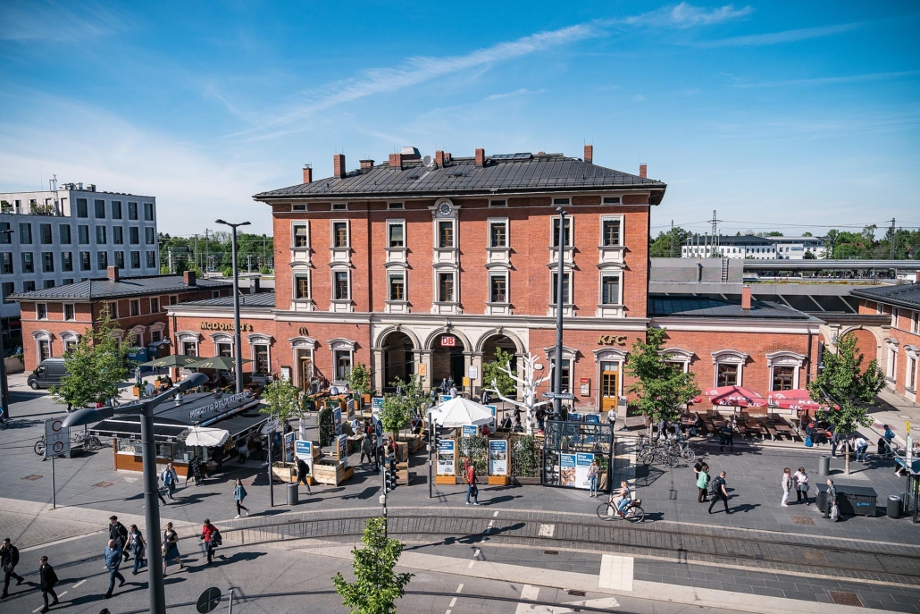 Bahnhof Pasing mit Menschen und Ständen.