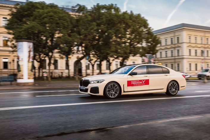 Weißes Auto fährt durch die Stadt.