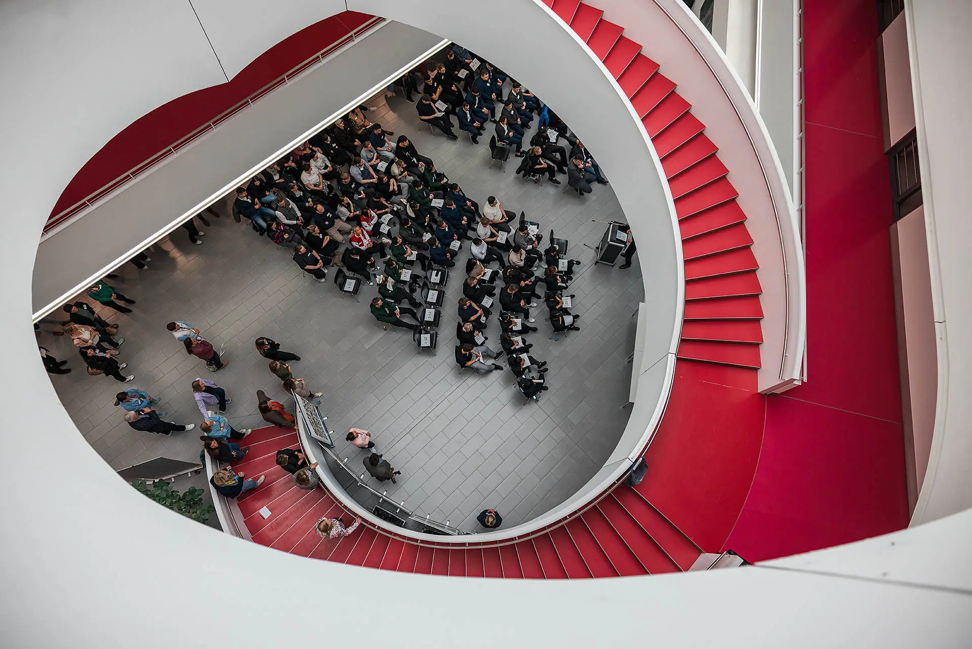 Rote Treppe mit Menschenmenge darunter