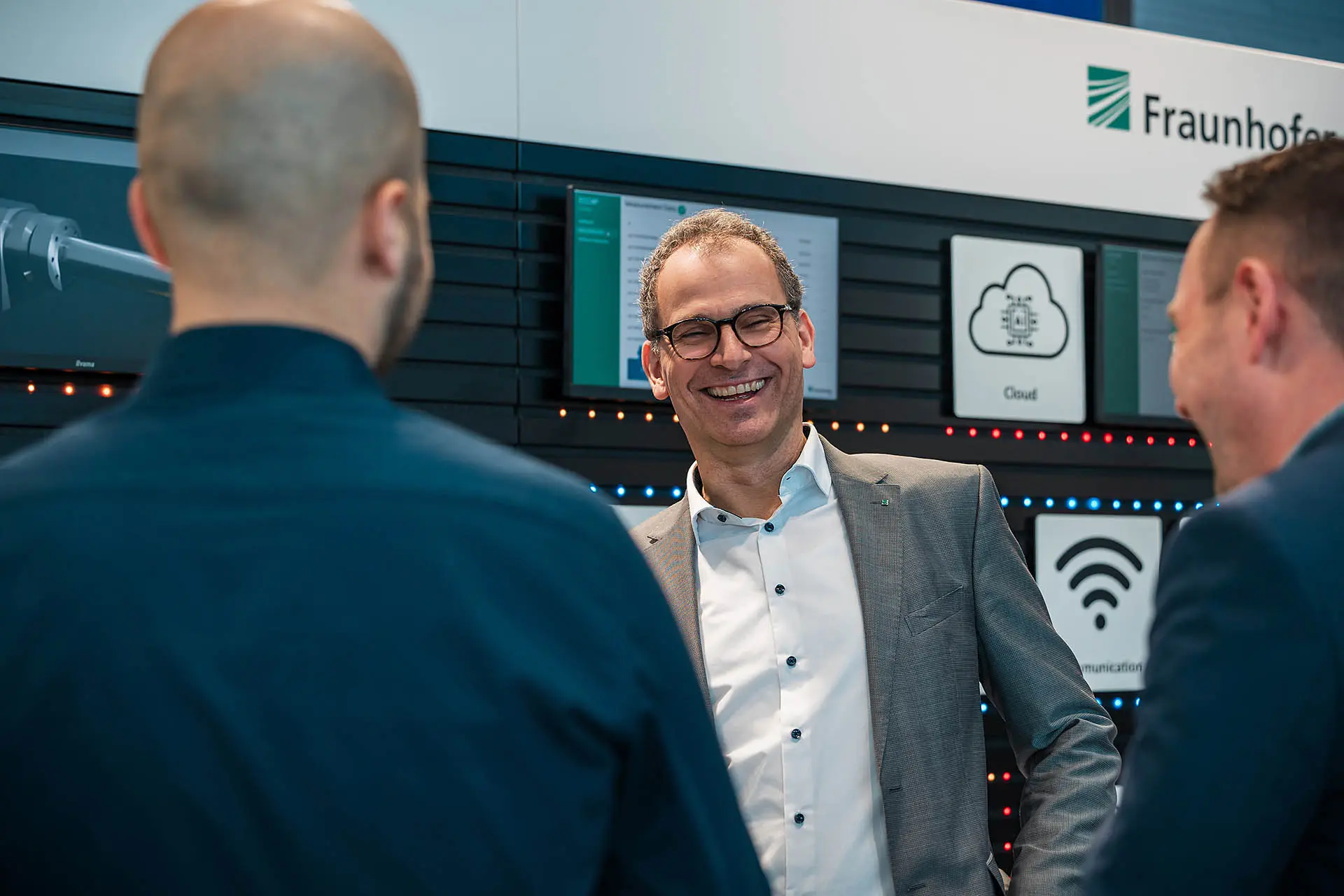 Menschen am Fraunhofer-Stand diskutieren.
