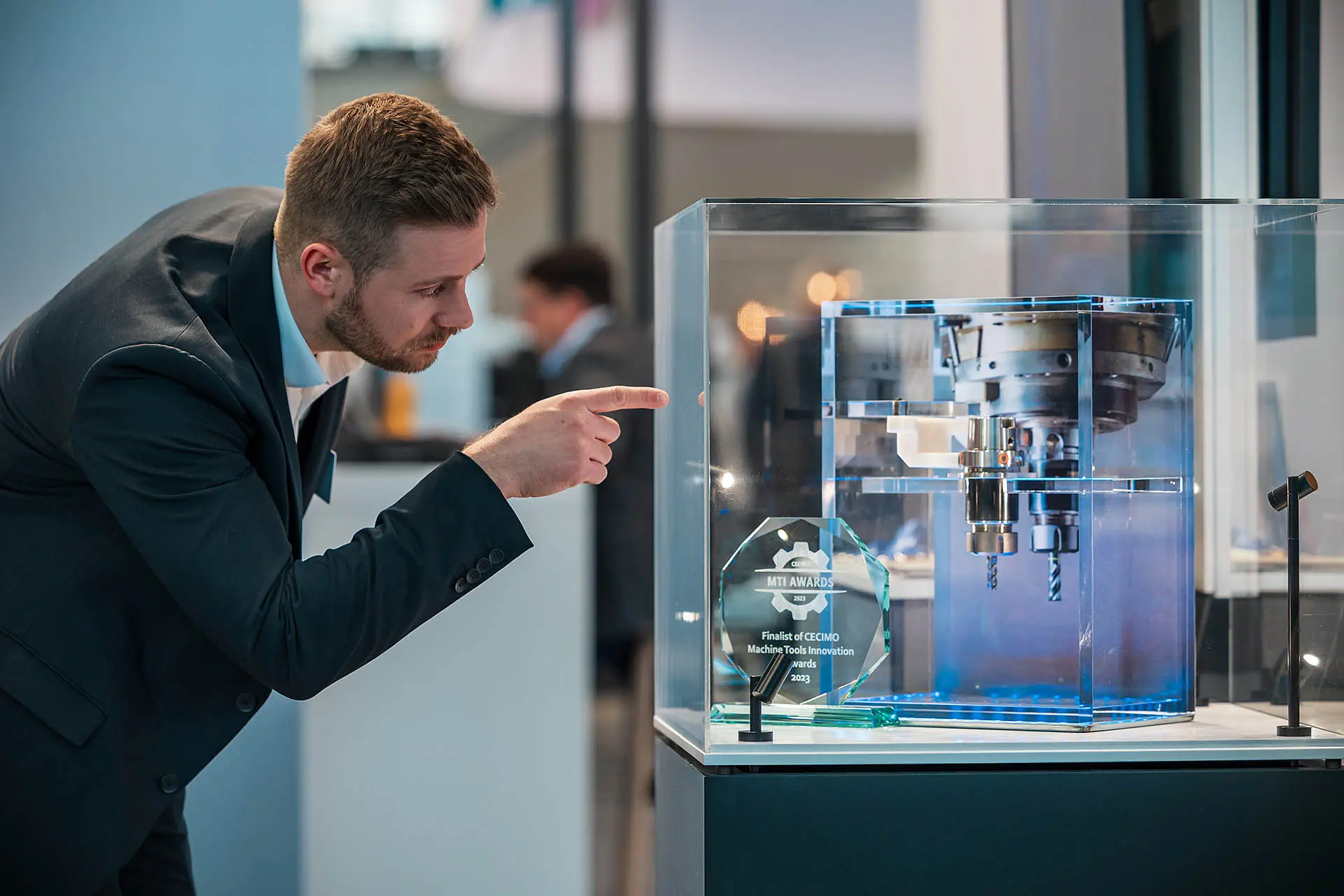 Mann zeigt auf technische Ausstellung.