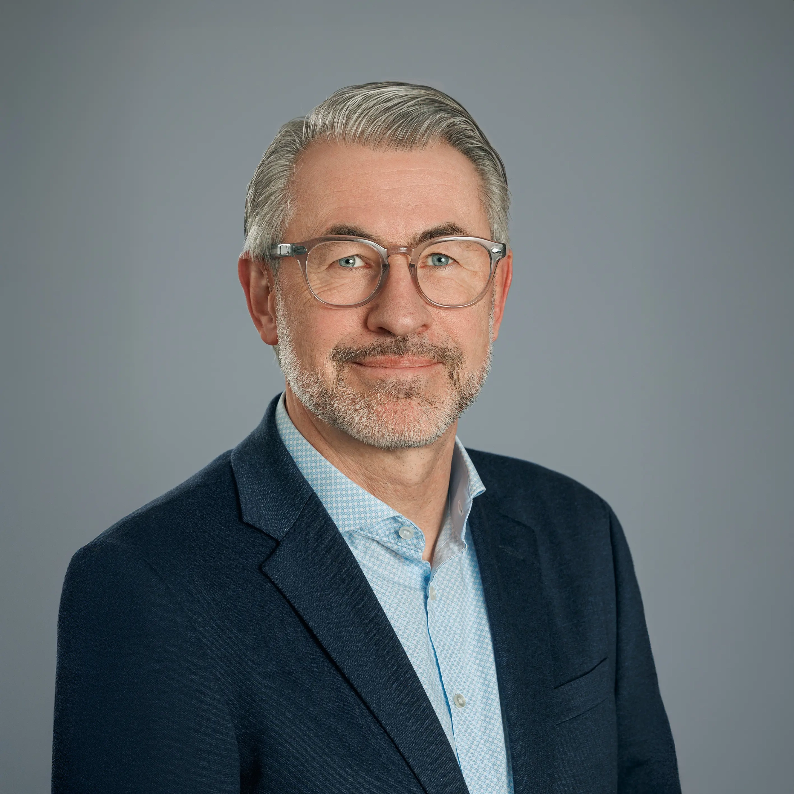 Mann in Anzug vor grauem Hintergrund