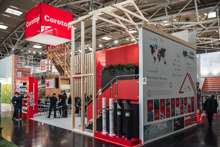 Messestand mit roten Elementen und Informationen.