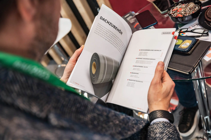 Person blättert in einem Katalog.