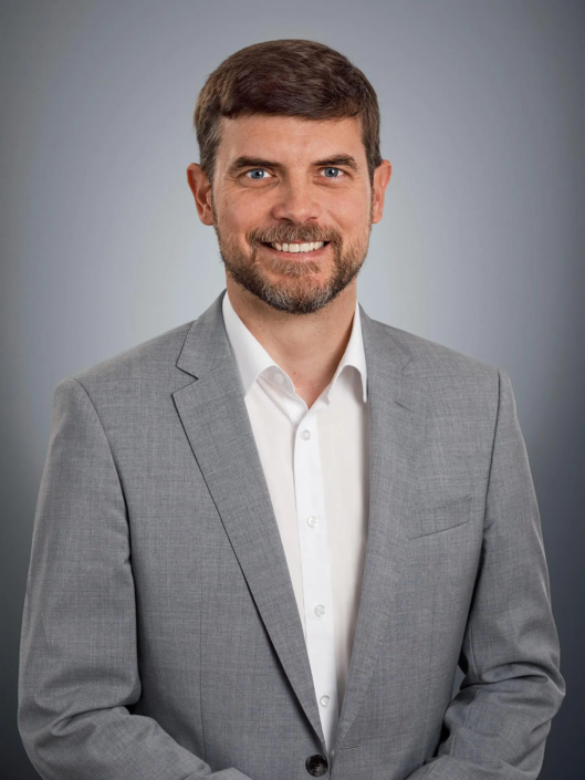 Mann im Anzug vor neutralem Hintergrund, Günstige Bewerbungsfotos in München