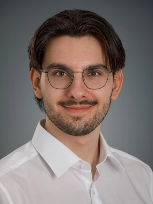 Mann mit weißem Hemd, neutraler Hintergrund.